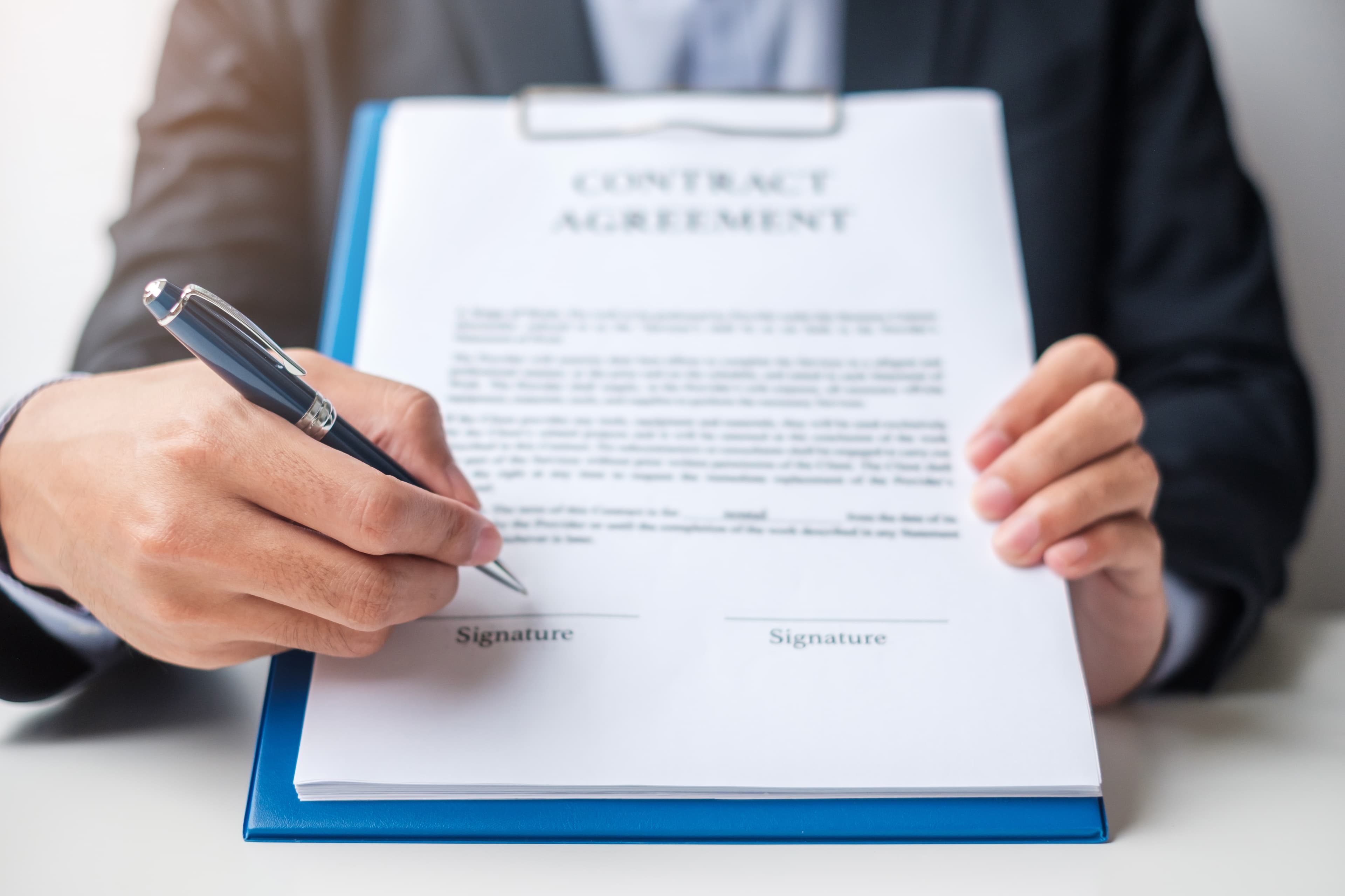 Business owner signing unsecured funding documents at their desk